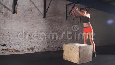 适合运动的女人在废弃的工厂健身房里做盒子跳跃。 剧烈运动是她日常交叉健身的一部分